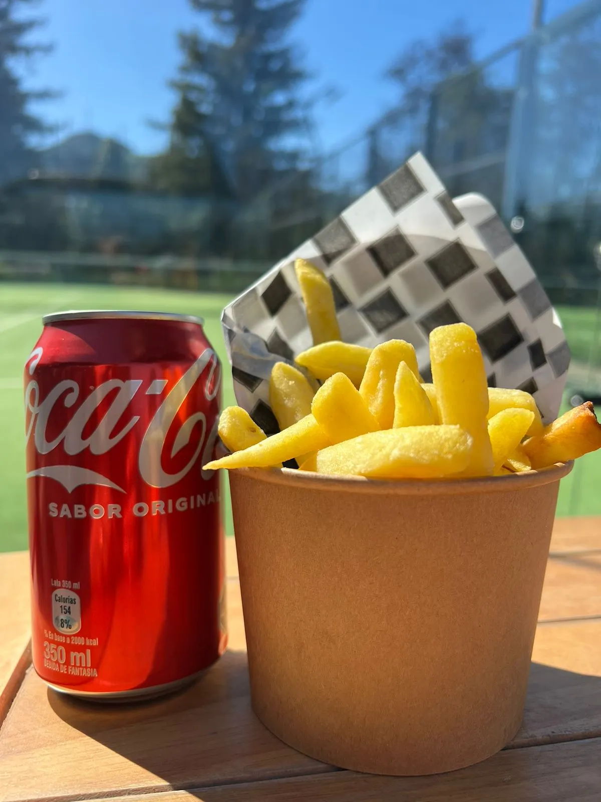 Papas fritas acompañadas de una lata de bebida